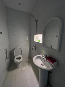 a bathroom with a toilet and a sink and a mirror at أجنحة عبدالعزيز للوحدات السكنية in Sulţānah