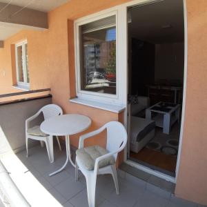 a table and chairs on a balcony with a window at Apartman Marija, Lukavica, Istočno Sarajevo in Lukavica