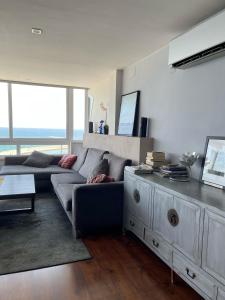 a living room with a couch and a table at ROSAS Vue sur Mer in Roses