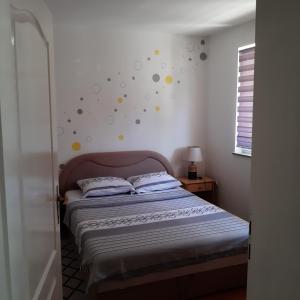 Schlafzimmer mit einem Bett mit Polka-Punkten an der Wand in der Unterkunft Apartman Marija, Lukavica, Istočno Sarajevo in Lukavica