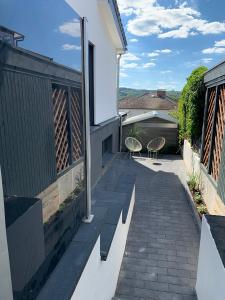 a patio with two chairs on the side of a house at Schickes Apartment mit direkter Waldrandlage in Geisenheim