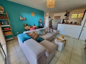 a living room with a couch and a blue wall at La Vita Bella, Superbe Apt T2 récent de 46m2 à St Gilles l'Eperon à 8min des plages in Saint-Gilles-les Hauts