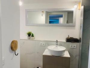 a white bathroom with a sink and a mirror at Schickes Apartment mit direkter Waldrandlage in Geisenheim