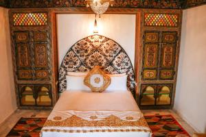 a bedroom with a bed with an ornate headboard at Riad Fez Mahal in Fès