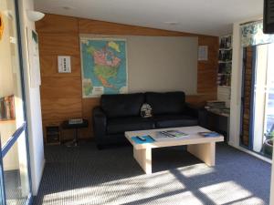 a living room with a couch and a coffee table at Stay in School by the Sea in Dunedin
