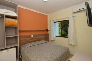 - une chambre avec un lit et une fenêtre dans l'établissement Refúgio Costeiro II, à Bombinhas