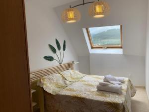 een slaapkamer met een bed met twee handdoeken erop bij Ático en Boiro La Niña, a 50m. Playa Jardín. in Boiro