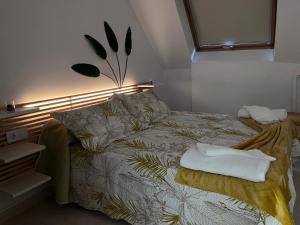 een slaapkamer met een bed met een lamp en handdoeken erop bij Ático en Boiro La Niña, a 50m. Playa Jardín. in Boiro