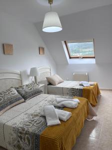 ein Schlafzimmer mit zwei Betten und einem Fenster in der Unterkunft Ático en Boiro La Niña, a 50m. Playa Jardín. in Boiro + 11 Fotos