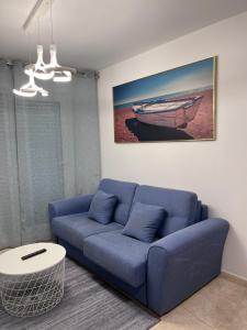 ein Wohnzimmer mit einem blauen Sofa und einem Tisch in der Unterkunft Ático en Boiro La Niña, a 50m. Playa Jardín. in Boiro