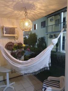a hammock hanging from the ceiling of a patio at Refúgio Esmeralda in Guarajuba