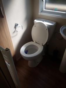 een badkamer met een wit toilet en een wastafel bij 6 Berth Caravan on Lakeside Holiday Park in Burnham on Sea