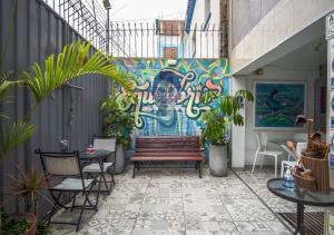 a patio with a bench and a wall with a mural at Magdalen House in Lima
