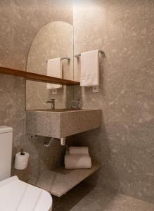 een badkamer met een wastafel en een spiegel en een toilet bij Apartamento Salinas Premium Resort in Salinópolis