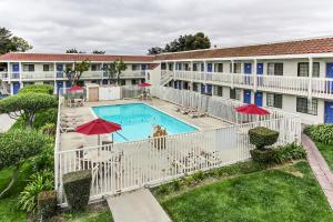 una vista aérea de la piscina en un hotel con sombrillas rojas en Motel 6-Salinas, CA - North Monterey Area, en Salinas