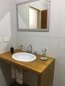 uma casa de banho com um lavatório branco e um espelho. em Real .Departamento em Luján