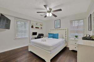 a white bedroom with a bed and a ceiling fan at Atlanta Retreat Message For Spring Special in Atlanta