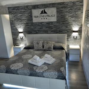 1 dormitorio con 1 cama grande y 2 toallas. en B&B Etnea Palace en Catania