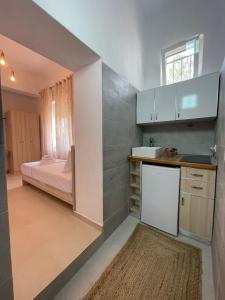 a kitchen with a sink and a bed in a room at Skrapari Studio Apartment in Çorovodë