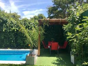 un patio con mesa y sillas junto a una piscina en Casa ideal para familia, a minutos de Buenos Aires en Martínez