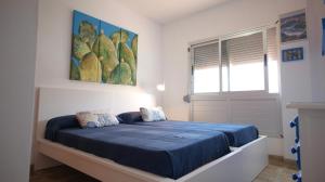 um quarto com uma cama com lençóis azuis e uma janela em Apartamento en La Caleta El Hierro em Valverde