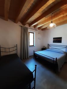 a bedroom with two beds and a window at SEMI AL VENTO: la bio-casa nel giardino incantato! in Paesana