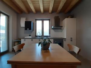 eine Küche mit einem großen Holztisch und Stühlen in der Unterkunft SEMI AL VENTO: la bio-casa nel giardino incantato! in Paesana