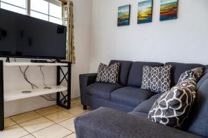 a living room with a blue couch and a tv at Seaside Adventure Lodging in Ensenada