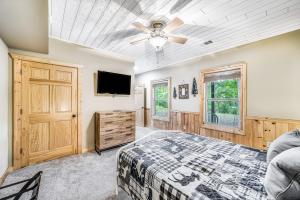 a bedroom with a bed and a flat screen tv at Deer Run Retreat in Ellijay