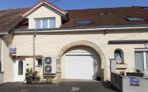 ein Haus mit einer Garagentür und einem Gebäude mit in der Unterkunft gîte Les Coquelicots in Médière