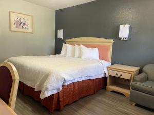 una habitación de hotel con una cama y una silla en Stratford Inn, en Stratford 10 fotos más