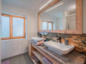 een badkamer met 2 wastafels en een spiegel bij Haus Bernadette in Bramberg am Wildkogel