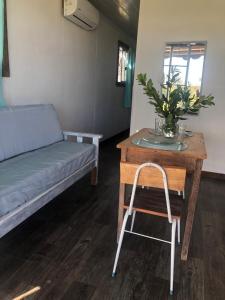 Habitación con mesa, cama y silla en Uy - ROMÁNTICA Cabaña en entorno Natural único, en Mercedes