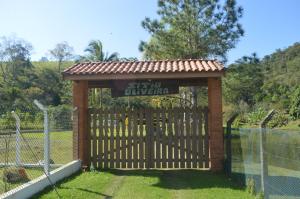 a gate in a fence with a sign on it at Sítio Oliveira in Itariri