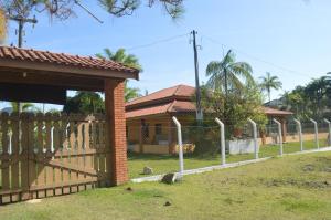 a fence in front of a house with a gate at Sítio Oliveira in Itariri