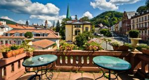 two tables on a balcony with a view of a city at Hotel Monpti in Heidelberg