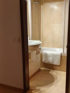 une salle de bain avec un lavabo et une baignoire dans l'établissement Casa Felicidade, à Lagos 76 autres photos