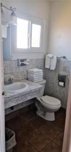 ein Bad mit einem WC, einem Waschbecken und einem Fenster in der Unterkunft North Coast Inn in Crescent City