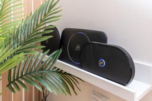 a black router sitting on a shelf next to a plant at Silver Stone Suite - in the heart of Aberdeen in Aberdeen