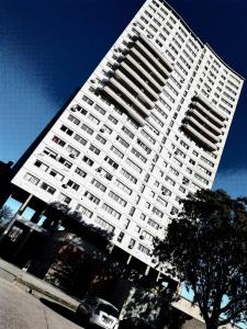 科尔多瓦Apartamento en piso 22 , con increíble vista! Ramón Bautista Mestre 1850, ANTIGUA CERVECERÍA CÓRDOBA的一座白色的大建筑,前面有一辆汽车