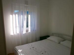 a bedroom with a white bed and a window at Seaside holiday house Trpanj, Peljesac - 16703 in Trpanj