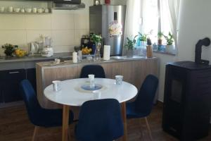 a kitchen with a white table and blue chairs at Seaside holiday house Trpanj, Peljesac - 16703 in Trpanj