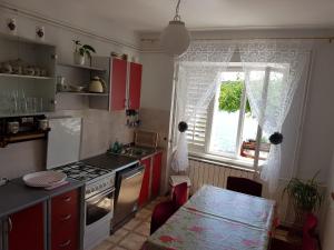 a kitchen with red cabinets and a table and a window at Seaside holiday house Barbat, Rab - 16712 in Rab