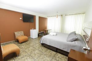 利馬的住宿－帕達瑪酒店，配有一张床和一把椅子的酒店客房