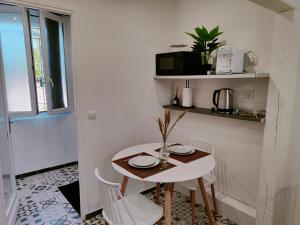 einen kleinen weißen Tisch und Stühle in einem Zimmer in der Unterkunft Studio cozy proche de Paris in Colombes