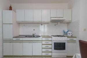 een witte keuken met een wastafel en een fornuis bij Apartments with a parking space Slatine, Ciovo - 16731 in Slatine