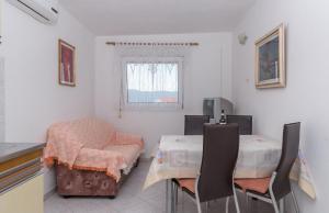 een eetkamer met 2 tafels en een stoel bij Apartments with a parking space Slatine, Ciovo - 16731 in Slatine