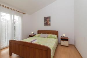 a bedroom with a large bed and two night stands at Apartments with a parking space Slatine, Ciovo - 16732 in Slatine