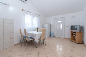 a dining room with a table and chairs and a tv at Apartments with a parking space Slatine, Ciovo - 16732 in Slatine