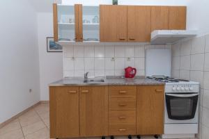 eine Küche mit einer Spüle und einem Herd Top-Backofen in der Unterkunft Apartments with a parking space Slatine, Ciovo - 16732 in Slatine
